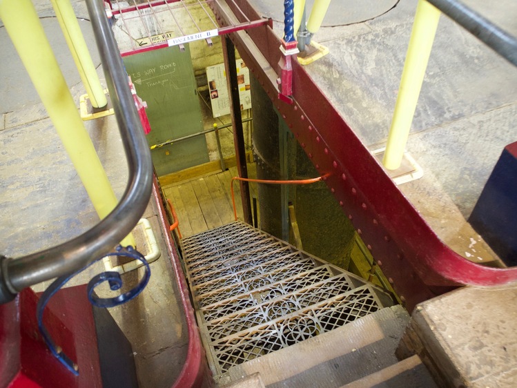 Looking down on some metal steps. The edge of the steps are painted red.